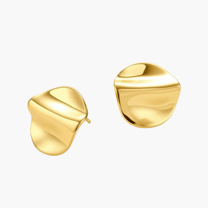 Close-up of organic gold-plated sterling silver stud earrings with flowing sculptural design and curved cut-outs